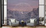 Mystic celestial zodiac wheel over snowy mountain peaks wall mural, styled in a modern living room with grey armchairs.
