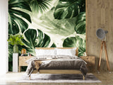 Close-up view of a dark green tropical Monstera leaf wallpaper mural on a textured background, available as peel and stick or non-woven